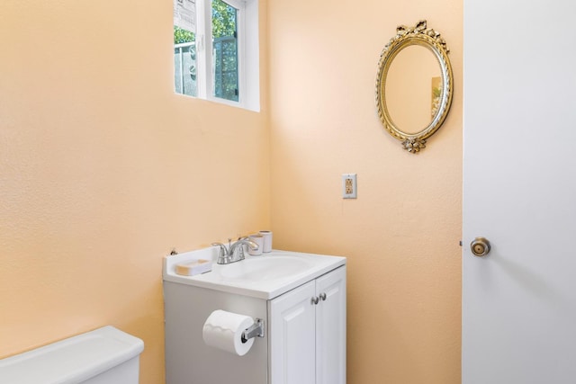 half bath featuring vanity and toilet