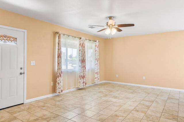 empty room featuring ceiling fan, visible vents, and baseboards