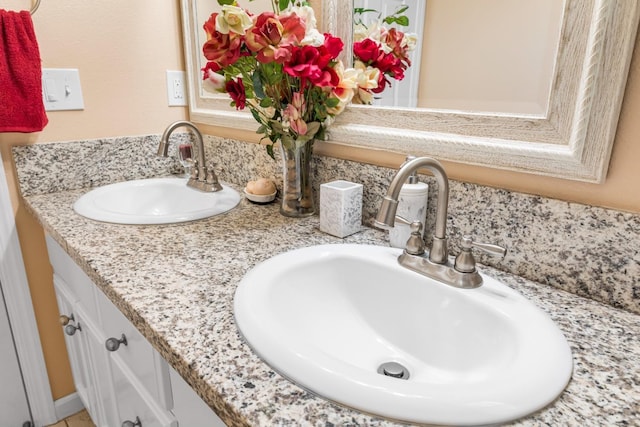 full bathroom with a sink and double vanity