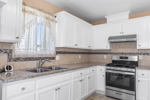 kitchen featuring decorative backsplash, stainless steel gas range, under cabinet range hood, white cabinets, and a sink