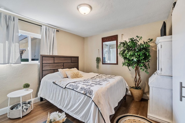 bedroom featuring baseboards and wood finished floors