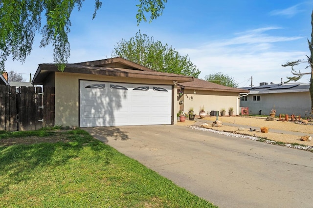 ranch-style home featuring fence, a garage, stucco siding, a front yard, and concrete driveway