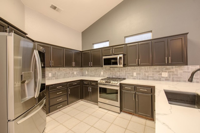 7224 N Bonadelle Ave, Fresno, CA 93720 - kitchen with appliances with stainless steel finishes, a sink, high vaulted ceiling, tasteful backsplash, and visible vents