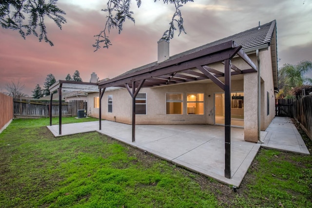 7224 N Bonadelle Ave, Fresno, CA 93720 - back of house at dusk with a chimney, a fenced backyard, a yard, a patio, and stucco siding