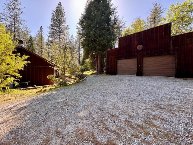 view of yard featuring a detached garage and gravel driveway