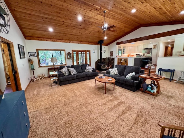 living area featuring carpet floors, vaulted ceiling, wooden ceiling, and a wood stove