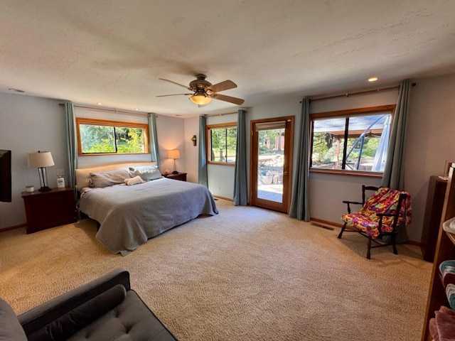 carpeted bedroom with baseboards, access to outside, a ceiling fan, and visible vents