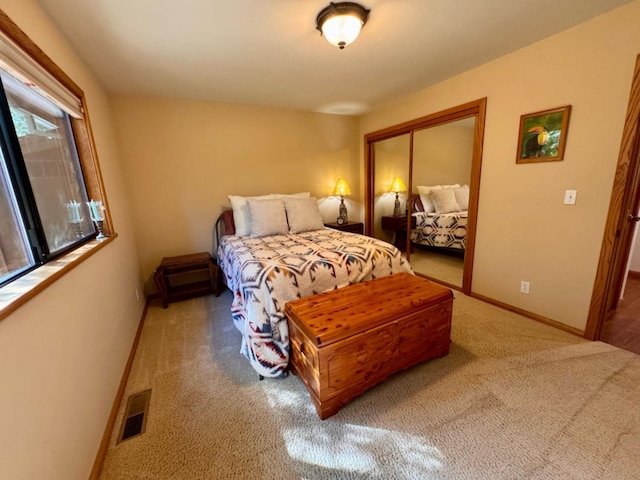 bedroom featuring a closet, baseboards, carpet flooring, and visible vents