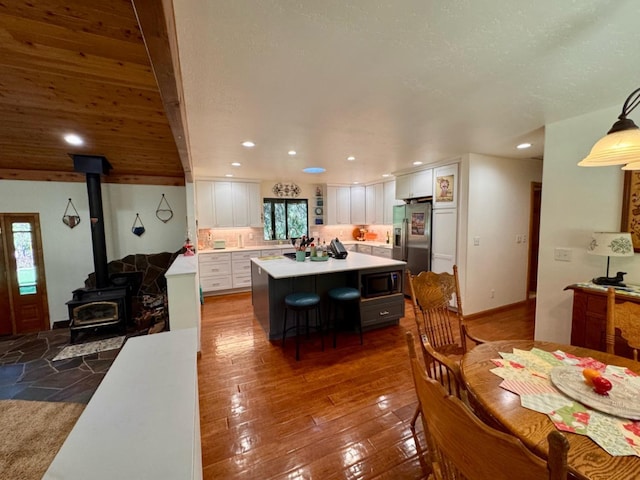 dining area featuring recessed lighting, a wood stove, and a wealth of natural light