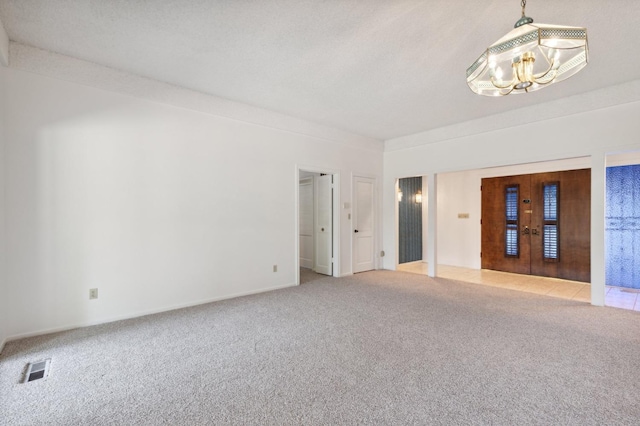 unfurnished room with french doors, visible vents, light carpet, and an inviting chandelier