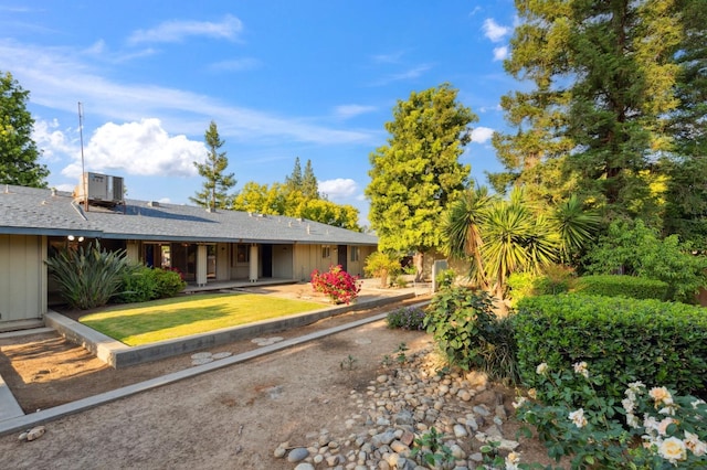 back of property featuring a yard, central AC, and board and batten siding