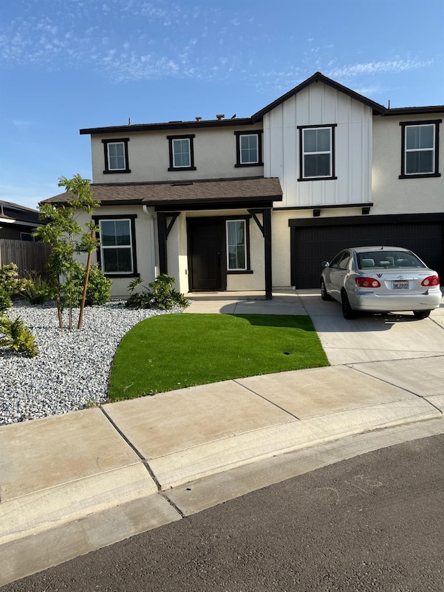 view of front of property featuring an attached garage, stucco siding, driveway, and a front lawn