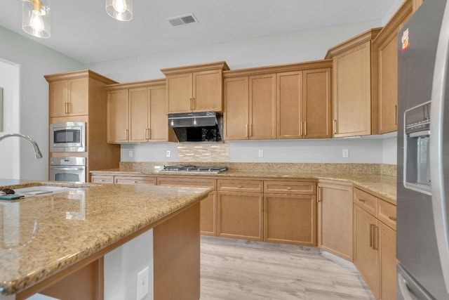 kitchen with visible vents, stainless steel appliances, a sink, light wood finished floors, and under cabinet range hood