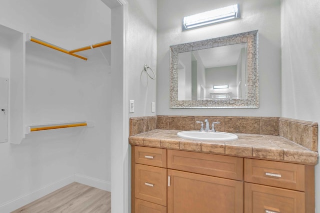 bathroom featuring vanity, baseboards, and wood finished floors