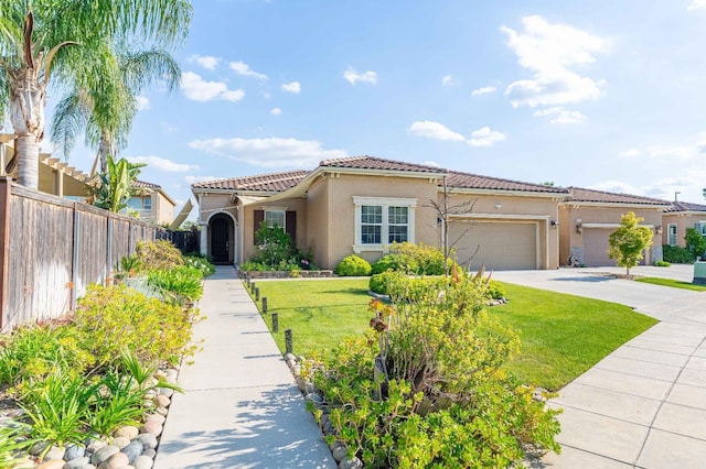 mediterranean / spanish-style home featuring a tiled roof, a front yard, fence, an attached garage, and stucco siding