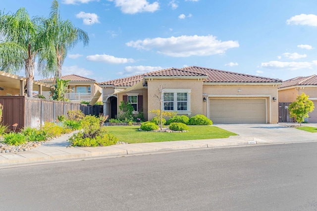 mediterranean / spanish home featuring a garage, fence, stucco siding, a tiled roof, and concrete driveway