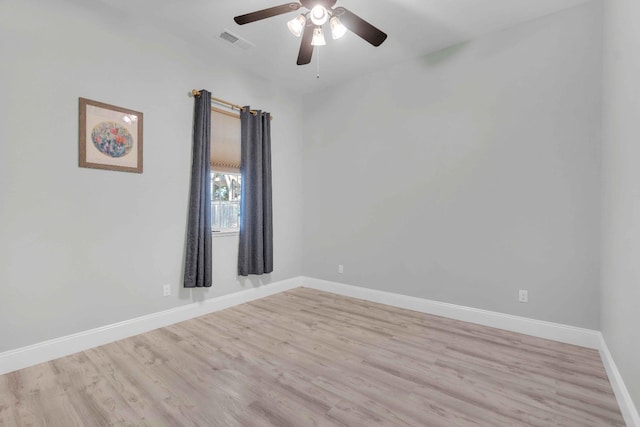 empty room with baseboards, ceiling fan, wood finished floors, and visible vents