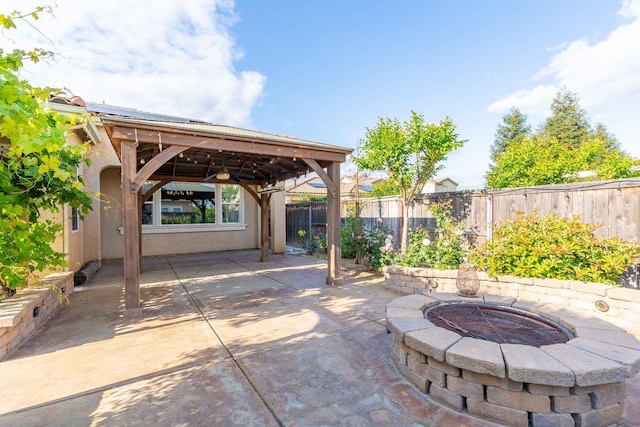 view of patio / terrace with a gazebo, a fenced backyard, and an outdoor fire pit