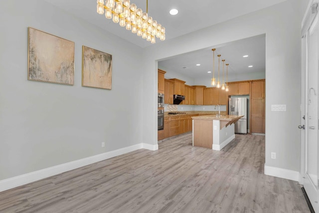 kitchen featuring a breakfast bar area, light countertops, baseboards, light wood finished floors, and stainless steel appliances