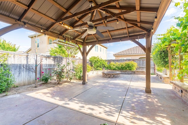 view of patio with a fenced backyard, a gazebo, a fire pit, and ceiling fan