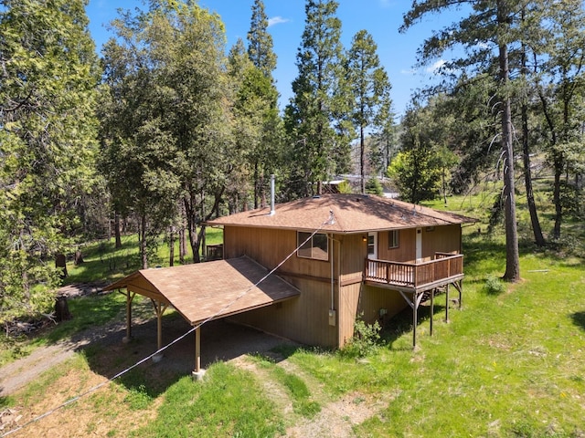 back of property with a wooden deck and roof with shingles