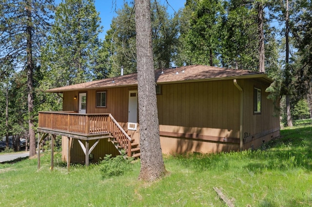 rear view of house with a shingled roof, stairway, and a deck