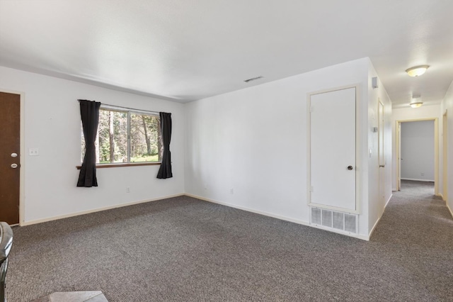 unfurnished room featuring baseboards, visible vents, and carpet