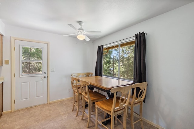 dining room with baseboards, ceiling fan, and a wealth of natural light