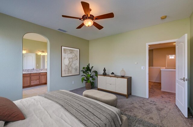 619 W Casanova Ln, Clovis, CA 93619 - bedroom with light colored carpet, arched walkways, a ceiling fan, and ensuite bathroom