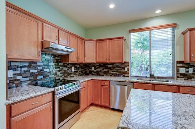 619 W Casanova Ln, Clovis, CA 93619 - kitchen featuring stainless steel appliances, under cabinet range hood, a sink, light stone counters, and light wood finished floors