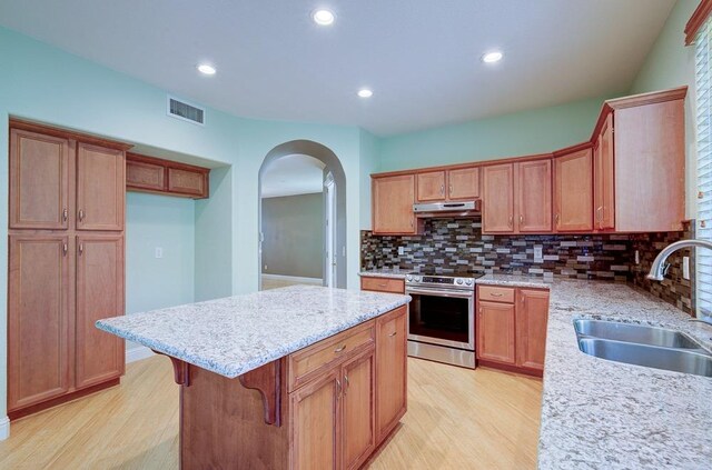 619 W Casanova Ln, Clovis, CA 93619 - kitchen with electric range, a sink, light wood-style flooring, under cabinet range hood, and backsplash