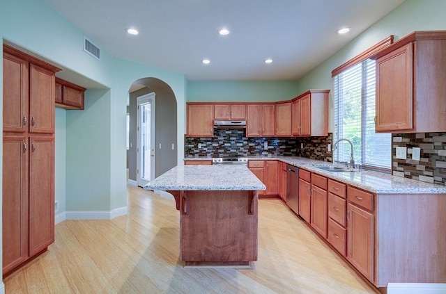 619 W Casanova Ln, Clovis, CA 93619 - kitchen featuring a sink, backsplash, light wood-type flooring, arched walkways, and stainless steel appliances