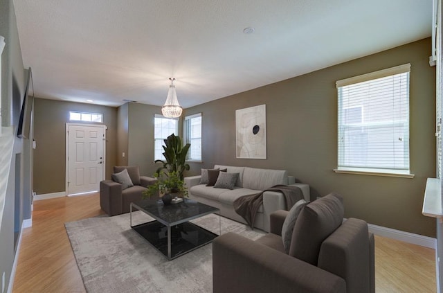 619 W Casanova Ln, Clovis, CA 93619 - living room with light wood-style flooring, baseboards, and a chandelier
