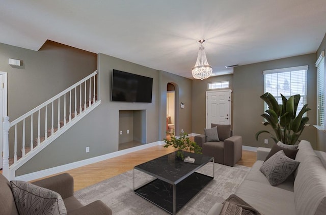 619 W Casanova Ln, Clovis, CA 93619 - living room featuring stairs, arched walkways, light wood-type flooring, a chandelier, and baseboards