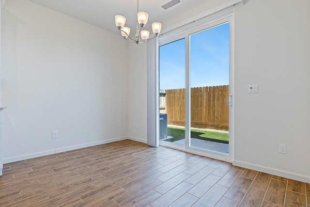 6260 E Malbec Dr, Fresno, CA 93727 - unfurnished room featuring visible vents, a chandelier, wood finished floors, and a healthy amount of sunlight