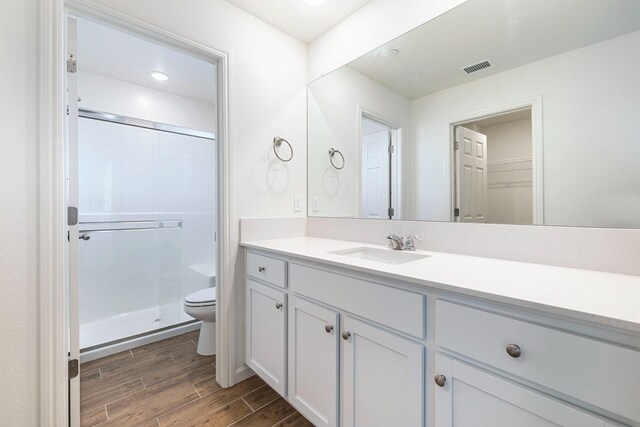 6260 E Malbec Dr, Fresno, CA 93727 - bathroom with visible vents, a stall shower, wood finished floors, vanity, and toilet