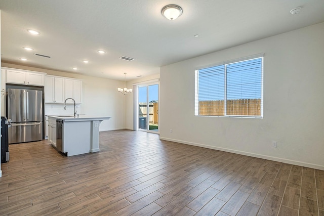 6260 E Malbec Dr, Fresno, CA 93727 - kitchen featuring an inviting chandelier, freestanding refrigerator, wood finished floors, and visible vents
