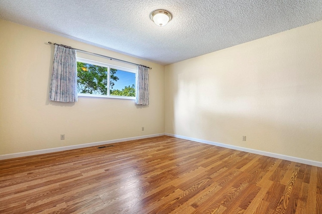6154 E Alta Ave, Fresno, CA 93727 - empty room featuring light wood-style floors, a textured ceiling, baseboards, and visible vents