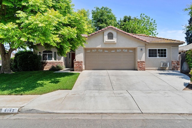 view of front facade with brick siding, an attached garage, a front lawn, and stucco siding