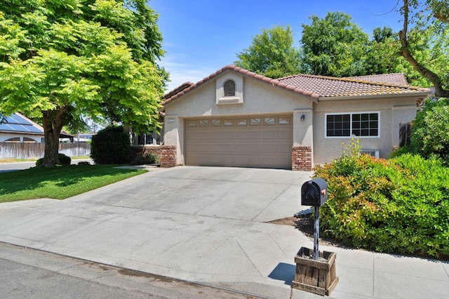 view of front of property featuring a garage, a front lawn, stucco siding, a tiled roof, and driveway