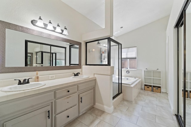 full bath featuring a sink, double vanity, a stall shower, and a garden tub