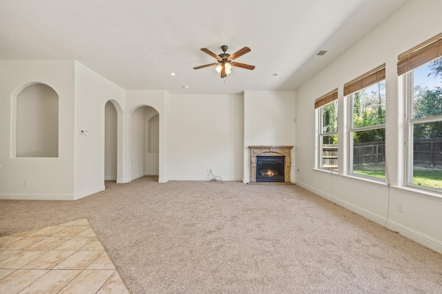 5534 N La Ventana Ave, Fresno, CA 93723 - unfurnished living room featuring ceiling fan, light colored carpet, a glass covered fireplace, baseboards, and visible vents