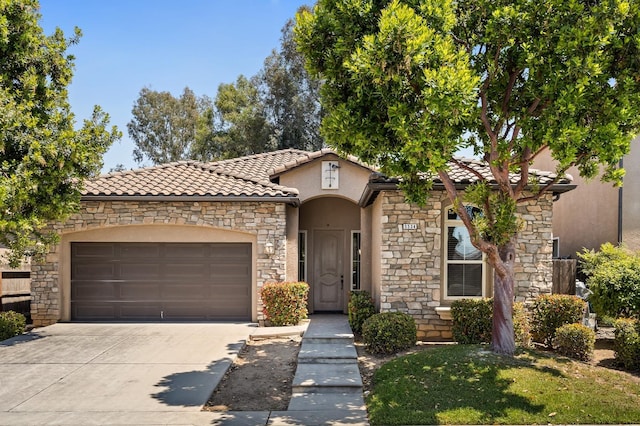 5534 N La Ventana Ave, Fresno, CA 93723 - view of front of house with a garage, stone siding, stucco siding, a tiled roof, and driveway