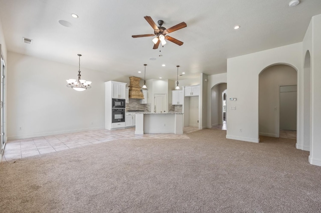 5534 N La Ventana Ave, Fresno, CA 93723 - unfurnished living room with light colored carpet, arched walkways, ceiling fan with notable chandelier, baseboards, and visible vents