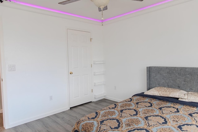 bedroom with baseboards, a ceiling fan, and wood finished floors