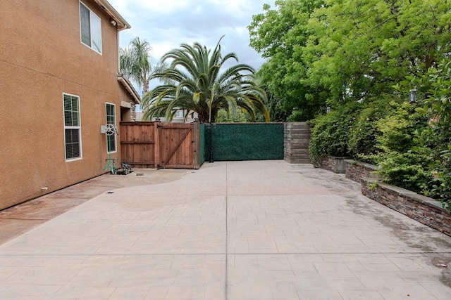 view of gate featuring a patio and fence