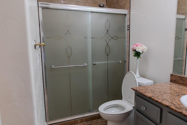 bathroom with vanity, toilet, and a shower stall