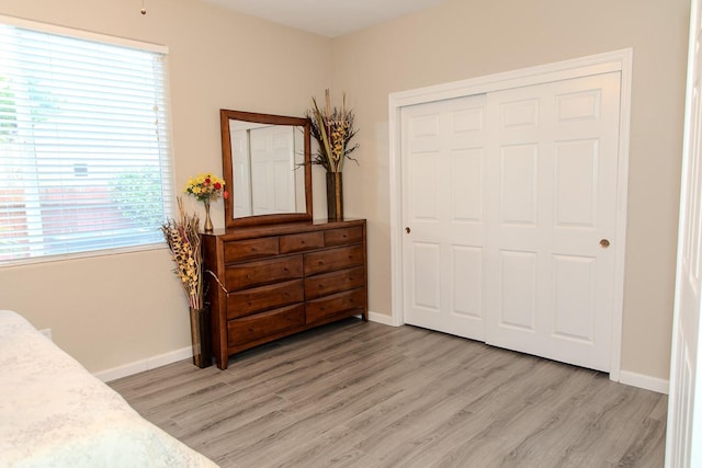 bedroom featuring a closet, baseboards, and light wood-type flooring