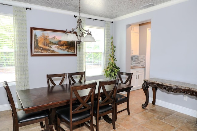 dining room with a textured ceiling, visible vents, ornamental molding, and baseboards