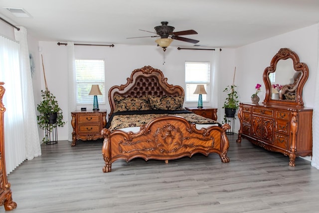 bedroom with a ceiling fan, visible vents, and light wood-style flooring